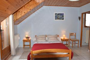 圣雷热雷梅累兹Les Garianes的一间卧室配有一张带两张桌子和两盏灯的床。