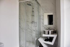 里斯本The Hygge Lisbon Suites - Estrela的一间带玻璃淋浴和水槽的浴室