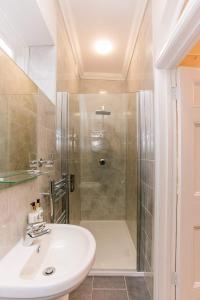 迪尔老神甫乡村民宿的带淋浴和白色盥洗盆的浴室