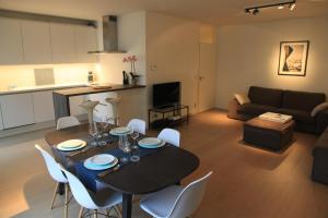 布鲁塞尔布鲁塞尔新设计公寓的厨房以及带桌椅的起居室。