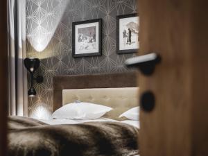 索尔登Valentin Design Apartments的卧室配有一张墙上三幅照片的床