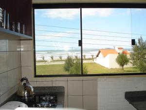 因比图巴Pousada Cheiro De Mar的厨房设有可欣赏海滩美景的窗户。