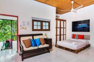 圣多明各La Puerta Roja Guest House的一间卧室配有一张床、一张沙发和一台电视。