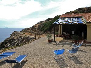 卡波利韦里Isola d'Elba Come in Barca, a un Tuffo dal Mare的一组椅子和一座海洋房子