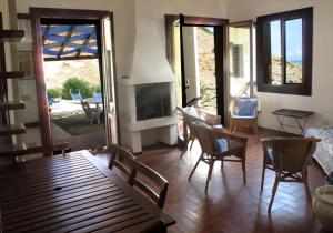 卡波利韦里Isola d'Elba Come in Barca, a un Tuffo dal Mare的客厅设有壁炉、桌子和椅子