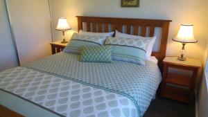 Hagley微光乡间民宿的一张带蓝色和白色枕头的床和两盏灯