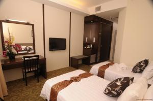 怡保森信酒店的酒店客房设有两张床、一张桌子和一台电视。
