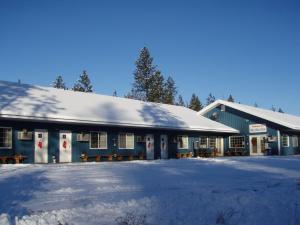 FruitlandWhite Willow Motel的一座蓝色的建筑,上面有雪