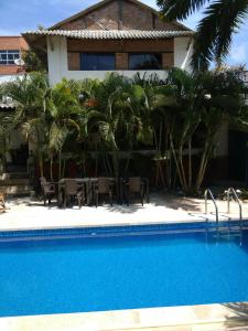 哥伦比亚港Hotel Boutique Casa Berastegui的棕榈树屋前的游泳池