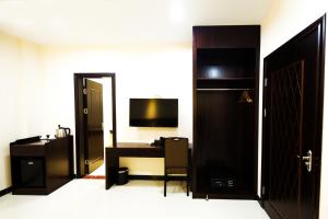 科罗尔京品酒店的酒店客房配有书桌和电视。