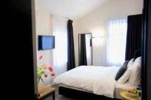 海法城市港口酒店的一间卧室配有一张带白色床单和窗户的床。