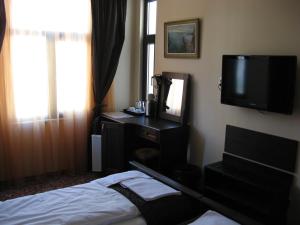 普罗夫迪夫Kapana Plovdiv的一间卧室配有一张床、一台电视和一面镜子
