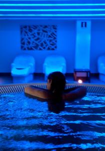 萨拉戈萨萨拉戈萨瑞市酒店及水疗中心的女人躺在游泳池里