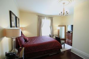 圣约翰斯The Rendell Shea Manor的一间酒店客房,配有红色的床和灯