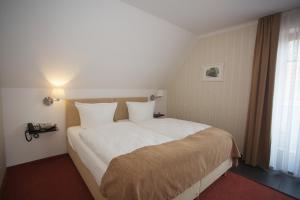 巴特多布兰多布哈纳霍夫酒店的卧室配有一张带白色床单的大床和窗户。