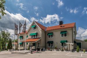 SkultunaSkultuna Hotell & Konferens的停车场有两面旗帜的建筑