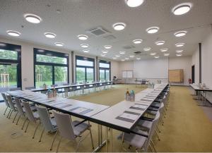 艾托弗西格股份有限公司古特汉肯霍夫高尔夫度假酒店的大型会议室,配有长桌子和椅子