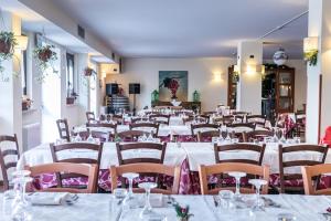 佩斯卡塞罗利Hotel Faggio Rosso的一间设有白色桌椅和粉红色餐巾的房间