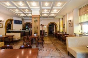 白采尔科维Отель "Соборный"的一间带桌椅的餐厅和一间酒吧