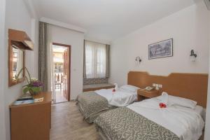 厄吕代尼兹贝尔塞汉海滩酒店的酒店客房设有两张床和窗户。