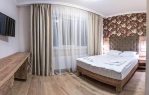 斯拉夫西克Рандеву的一间卧室设有一张床和一个大窗户
