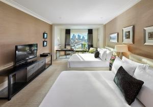 墨尔本Crown Towers Melbourne的酒店客房设有两张床和一台平面电视。