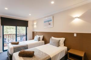 阿尔巴尼海豚公寓式酒店 - 米德尔顿海滩自助式公寓客房内的一张或多张床位
