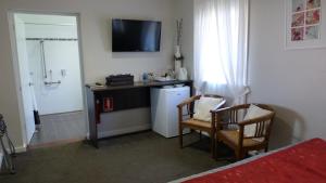 布里奇顿布里奇山谷汽车旅馆的一间客房配有冰箱和一张桌子及两把椅子