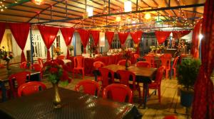 斯利那加Aziz Palace Group Of Houseboats的一间带桌椅和红色窗帘的用餐室