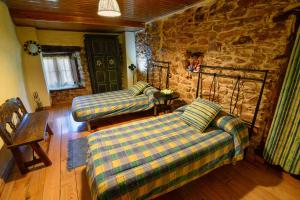 Lago de CarucedoCasa do Eiró的客厅设有两张沙发和一堵石墙