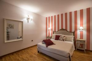 马蒂诺Al KamarTaj的一间卧室配有一张带条纹墙的床