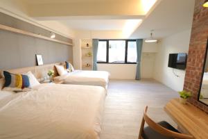 安平区花水木民宿 的一间酒店客房,设有两张床和电视