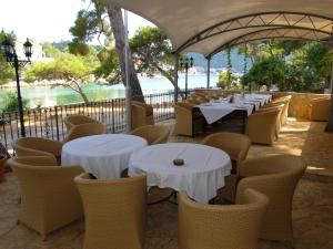 Ubli索利图德酒店的一间设有白色桌椅的餐厅,供应水