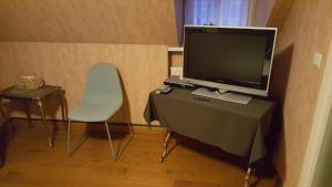 ArdooieRysselende Molen的配有电视、椅子和桌子的房间