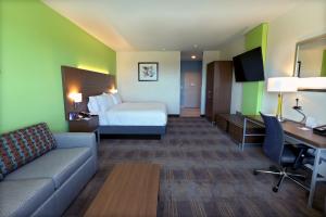 德里平斯普林斯Holiday Inn Express & Suites - Dripping Springs - Austin Area, an IHG Hotel的酒店客房配有一张床、一张沙发和一张书桌。