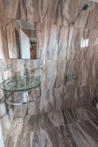 多布里尼什特Oasis Guest House的一间带玻璃水槽和淋浴的浴室