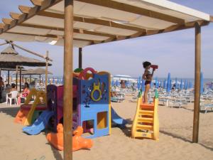 泰尔莫利梅里迪亚诺酒店的儿童在海滩上看游乐场的照片