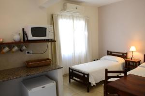拉巴斯Hotel Portal del Río的酒店客房配有两张床和微波炉。