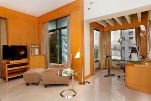 达卡湖滨酒店&公寓的客厅配有电视和桌椅