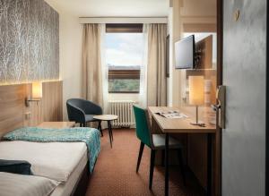 布拉格奥尔桑卡国会健康酒店的酒店客房配有书桌、床和桌子。