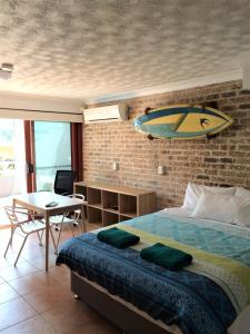 拜伦湾拜伦海滩公寓的卧室配有一张床铺,墙上设有冲浪板
