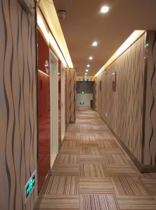 Fengxin尚客优连锁江西宜春奉新冯川东路黄泥巷店的走廊,位于一栋铺有木地板的建筑中