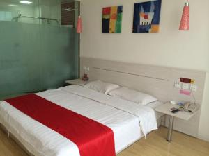 沧州尚客优连锁河北沧州解放西路店的一间卧室配有一张大床,铺有红白毯子