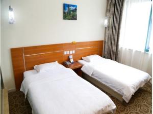 无锡尚客优连锁江苏无锡新区泰伯大道店的酒店客房设有两张床和窗户。