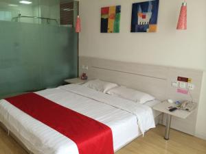 沧州尚客优连锁河北沧州解放西路店的一间卧室配有一张带红色毯子的大床