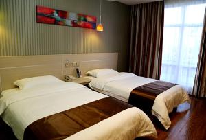Yanjun尚客优连锁辽宁鞍山海城万达店的酒店客房设有两张床和窗户。