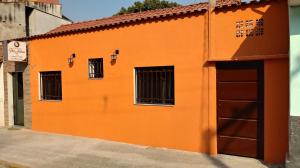 阿帕雷西达Pousada Pai Nosso的橙色的建筑,设有两扇窗户和一扇门