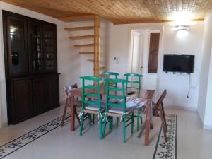 科尔萨诺Casa salento的一间配备有绿色椅子和桌子的用餐室