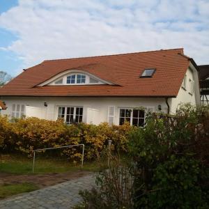 塞多夫Ferienhaus Boddenkiek mit Wasserblick in Seedorf的白色房子,有红色屋顶