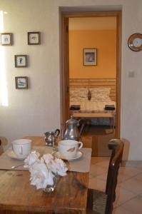 Les Iffs鲁杜门讷住宿加早餐旅馆的一张桌子,上面放着两个碗,上面放着茶壶
